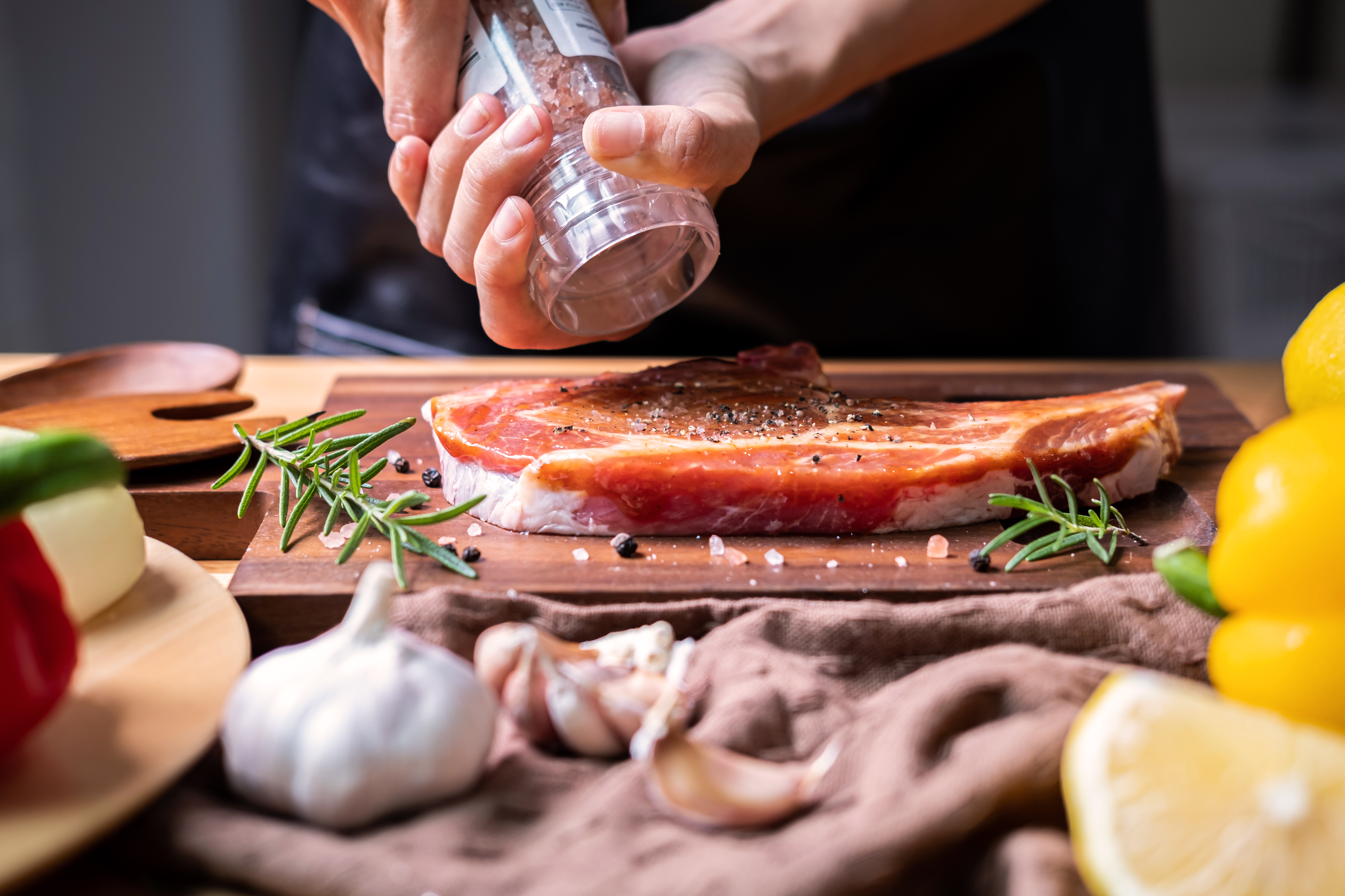 Chef prepares pork chop steak with barbecue sauce in the kitchen